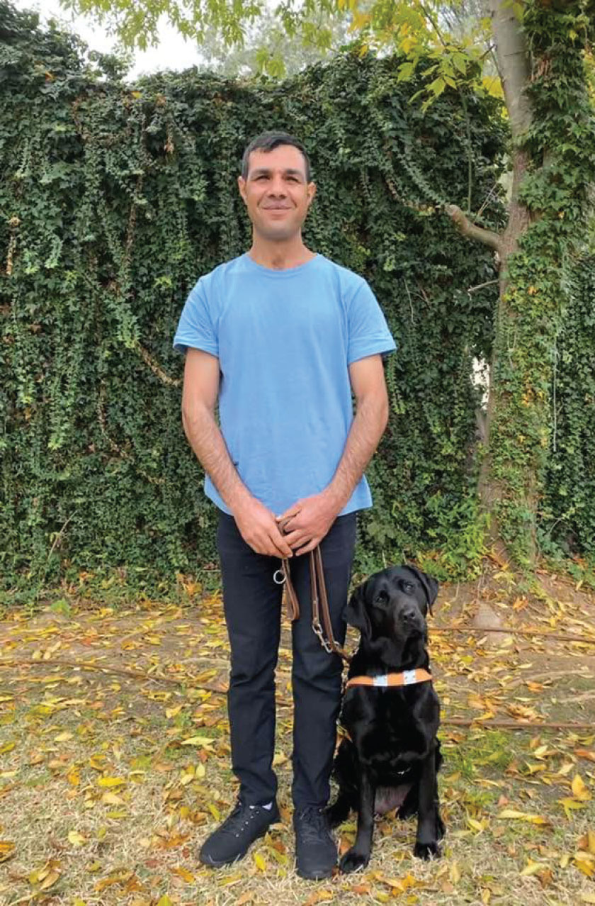 Ahmad Shehab with his Guide dog Tina in the woods.