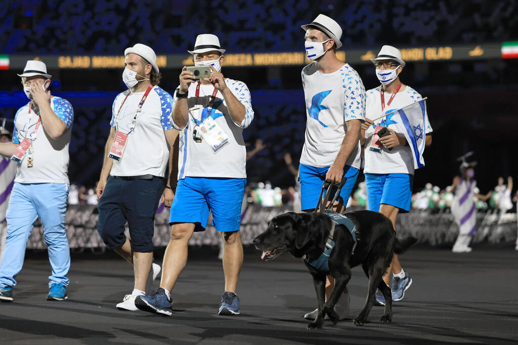 Group of Paralympic athletes walking in the opening ceremony.